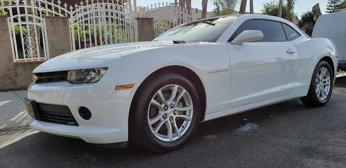 Freshly detailed white Chevrolet Camaro with glossy paint after a hand wash